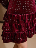 Close-up of burgundy velvet mini dress showing sparkling rhinestones and gathered skirt tiers