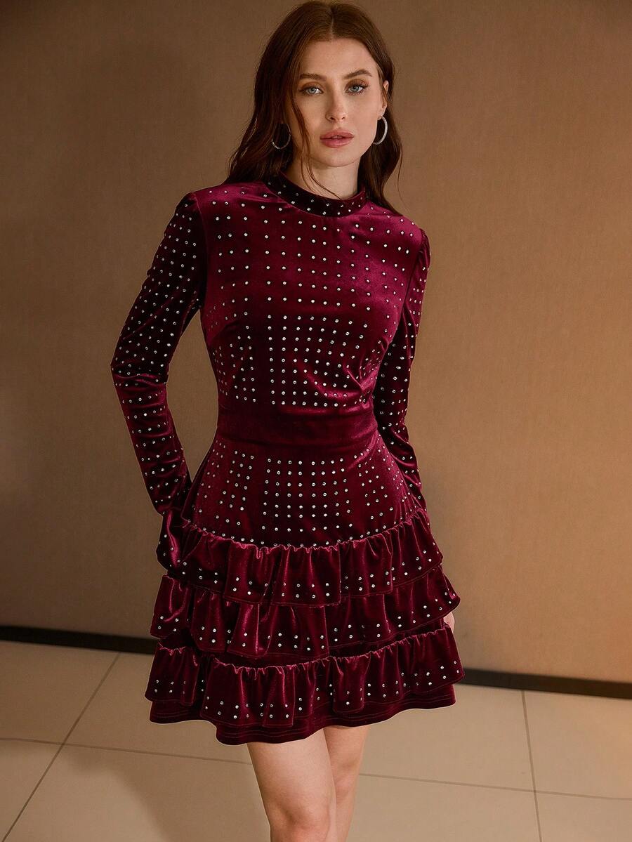 Front three-quarter view of burgundy rhinestone mini dress with fitted waist and ruffle tiers