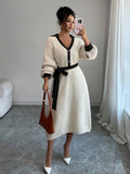 Front view of cream and black belted polo collar knit midi dress with bishop sleeves and button front