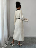 Back view of cream and black rib-knit A-line midi dress with high waist and long bishop sleeves