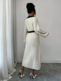 Back view of cream and navy rib-knit A-line midi dress with high waist and long bishop sleeves