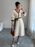 Close view of brown and cream button-front sweater midi dress with V-shaped polo collar and tied knit belt