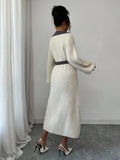 Front view of cream and grey belted polo collar knit midi dress with bishop sleeves and button front