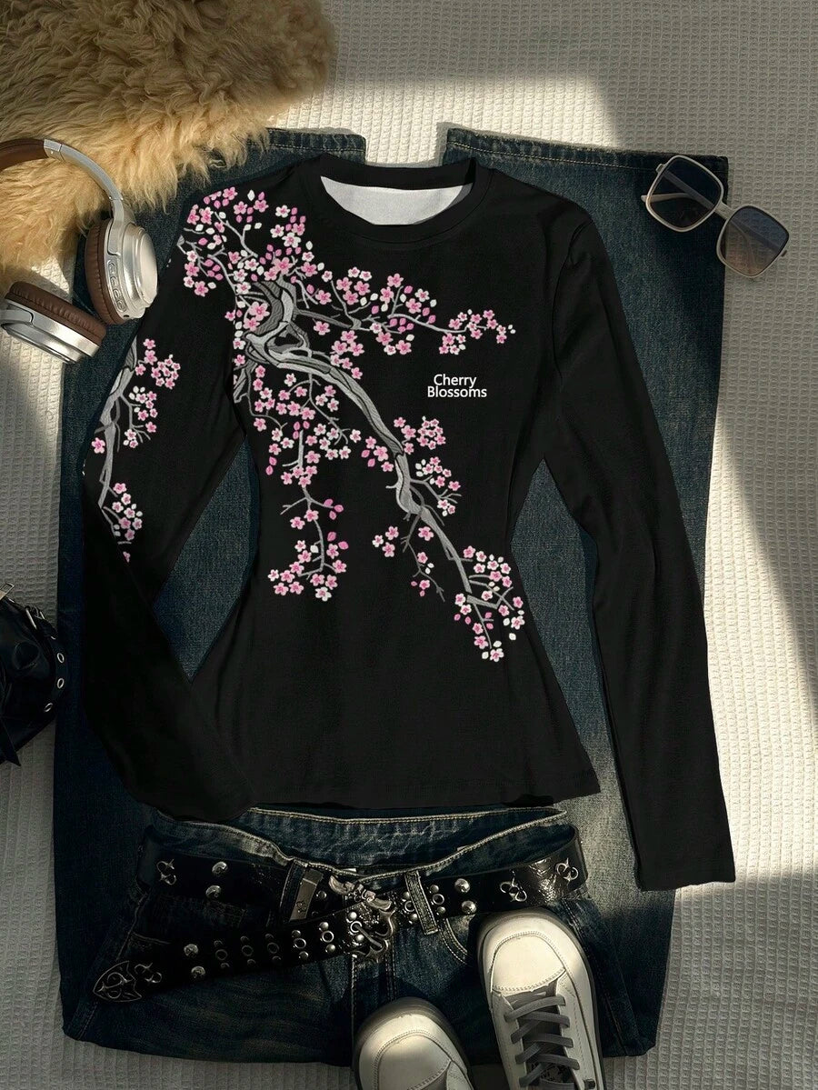 Front flat-lay of black fitted T-shirt with pink cherry-blossom branches and text