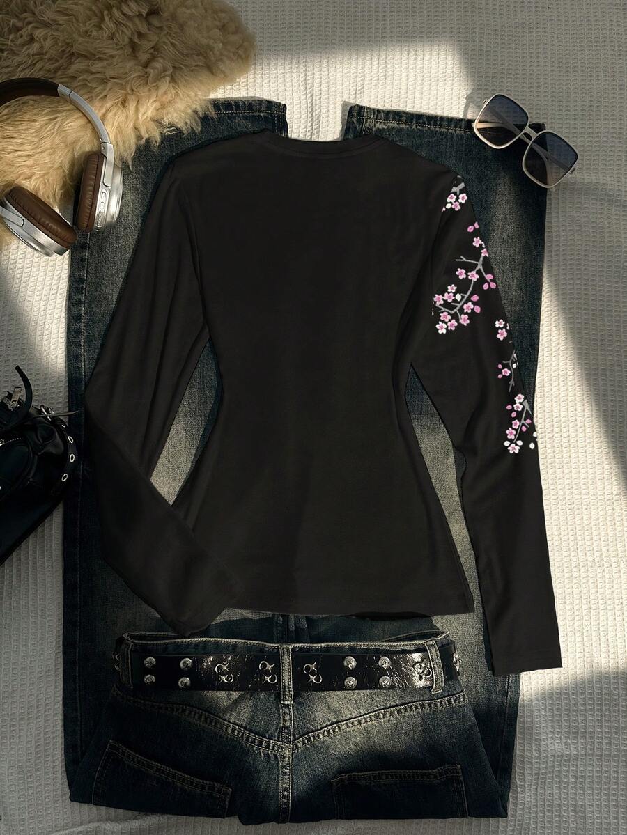 Back flat-lay of black long-sleeve top with cherry-blossom print on one sleeve