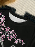 Close-up of ribbed crew neck and pink cherry-blossom graphic on black T-shirt