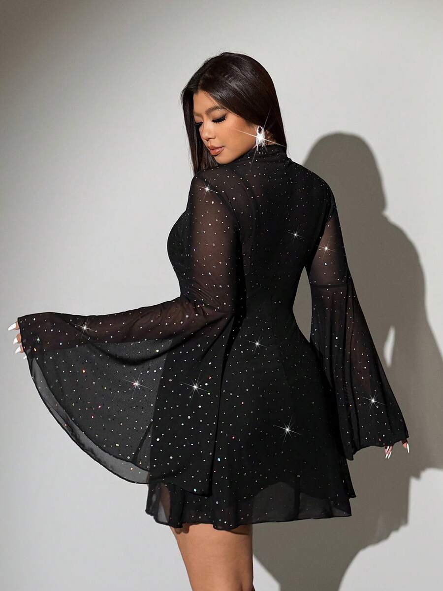 Front selfie view of black sheer embellished mini dress with long flared sleeves and camisole layer