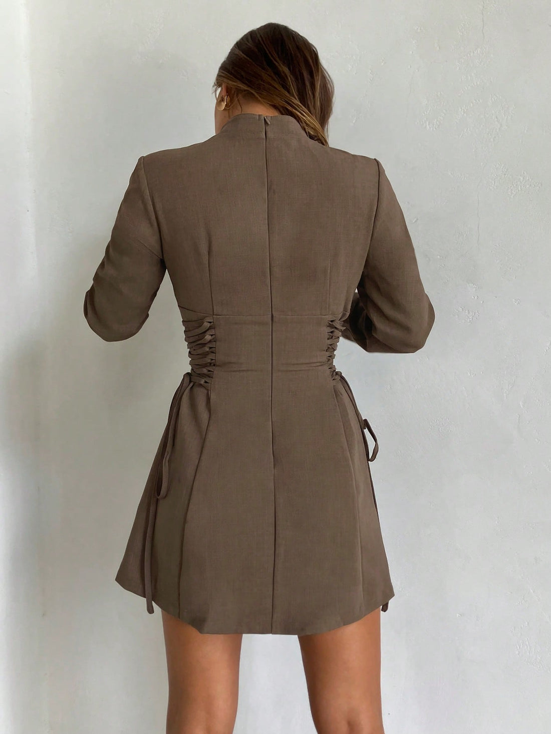 Elevate your seasonal wardrobe with this charming coffee brown mini dress that's equal parts cozy and chic. The statement puff sleeves add a playful touch while the criss-cross tie detail at the waist creates flattering definition. Perfect for autumn and winter gatherings, this versatile piece transitions effortlessly from casual coffee dates to evening outings. The rich brown tone pairs beautifully with boots, sneakers, or heels, making it a go-to favorite for any occasion.