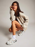 On-foot front side view of white colorblock mesh sneakers styled with beige clothing
