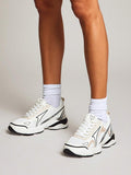 On-foot front three-quarter view of white lace-up mesh trainers with black accents