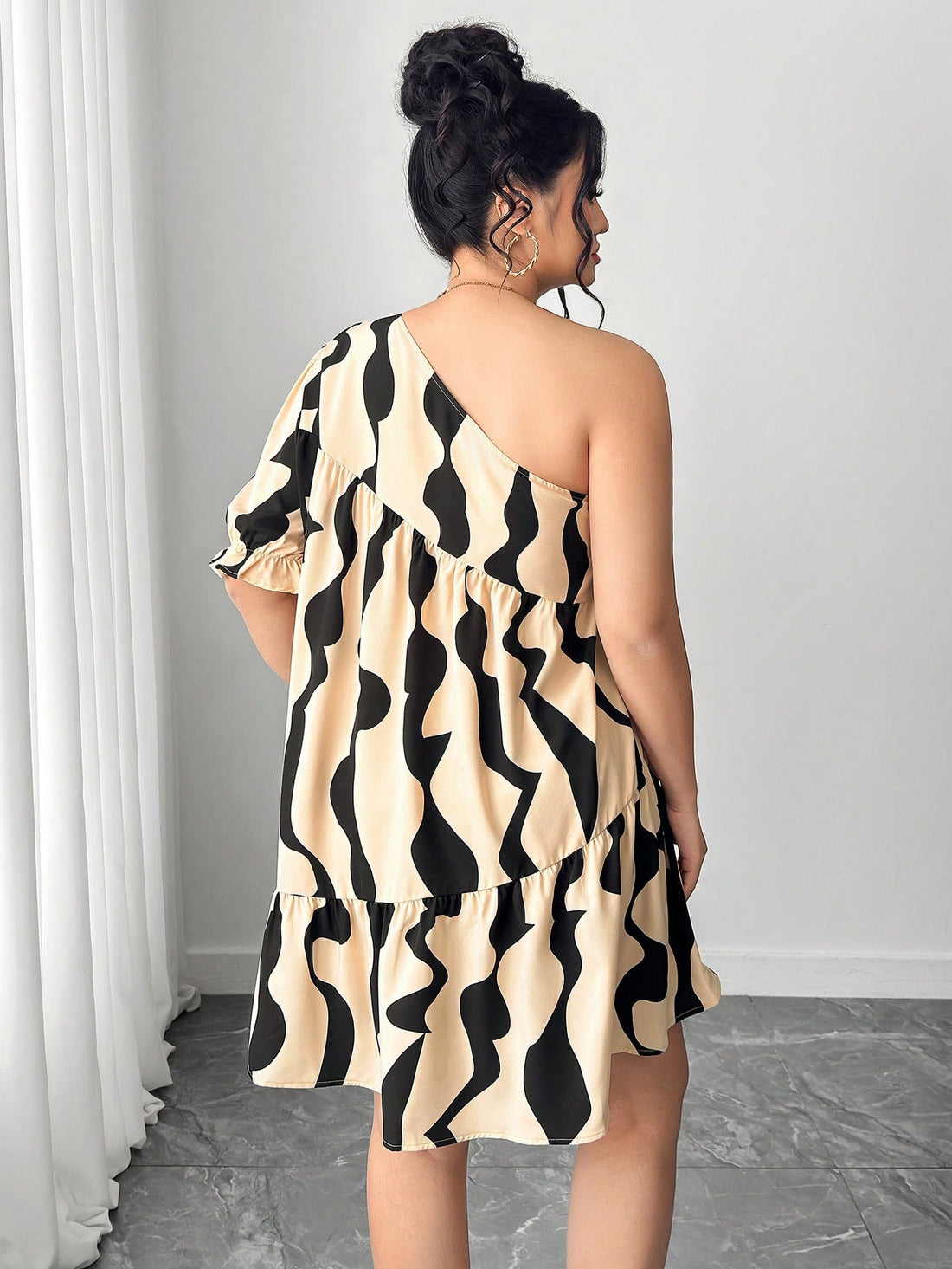 Embrace your curves with this show-stopping plus-size dress that proves minimalism can be bold. Layered geometric prints create visual intrigue while asymmetric lantern sleeves add a playful twist that catches every eye. The thoughtful construction flatters your silhouette, offering comfort without compromise. Perfect for turning heads at brunch, date night, or whenever you want to feel effortlessly chic. This dress celebrates your style with personality and flair.