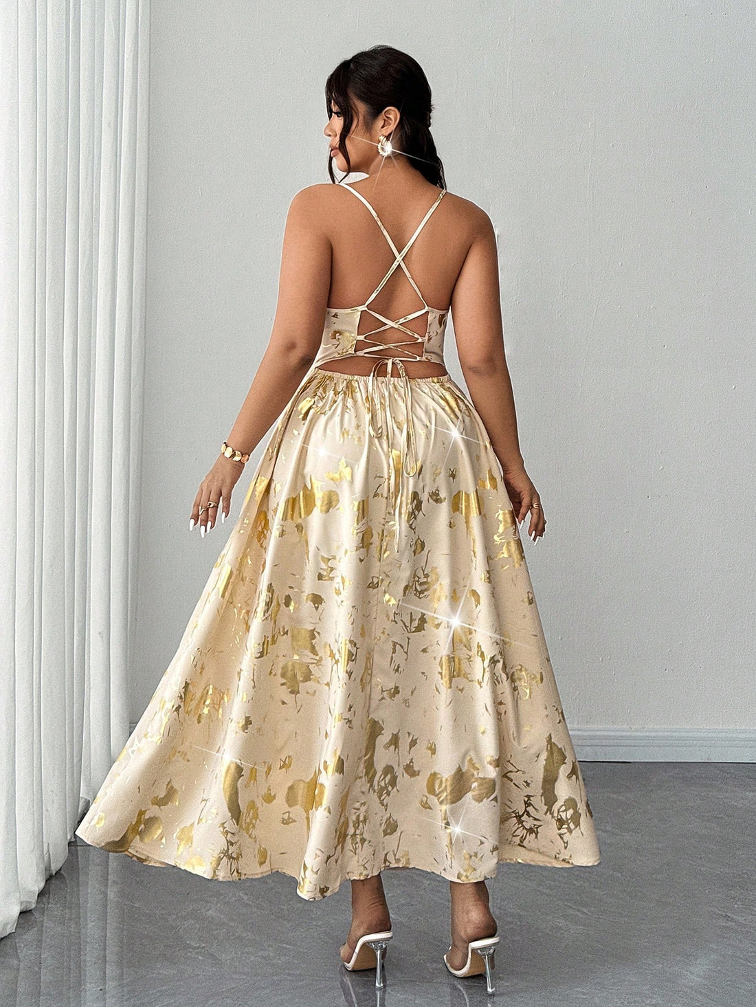 Make a statement this season in our stunning metallic foil spaghetti strap dress—the perfect pick for summer soirées and unforgettable celebrations. Designed with plus-size curves in mind, this show-stopping piece features a shimmering foil finish that catches the light beautifully, delicate spaghetti straps, and a daring backless silhouette that's equal parts glamorous and fun. Whether you're heading to a garden party, wedding reception, or night out with friends, this dress delivers confidence and sparkle