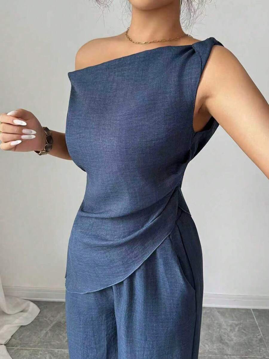 Sophisticated two-piece set designed for tall women who value understated elegance. The navy blue pleated blouse features clean lines and refined tailoring, paired with matching high-waisted pants that elongate the silhouette

