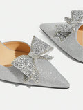 close-up of rhinestone bow on silver glitter pointed-toe pump