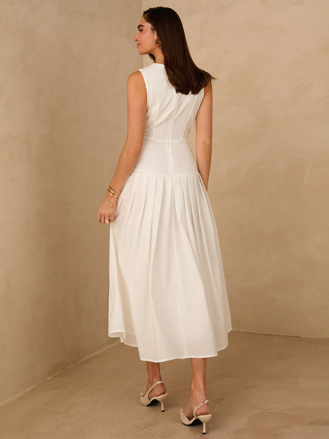 Elevate your seasonal wardrobe with this sophisticated white sleeveless dress, designed for effortless elegance. The flowing silhouette features a refined pleated hem that adds movement and visual interest, while the sleeveless cut keeps you cool during warm months. Crafted for versatility, this piece transitions seamlessly from casual daytime wear to evening occasions. The clean white palette pairs beautifully with layered accessories or statement jewelry, making it an essential investment for spring and s