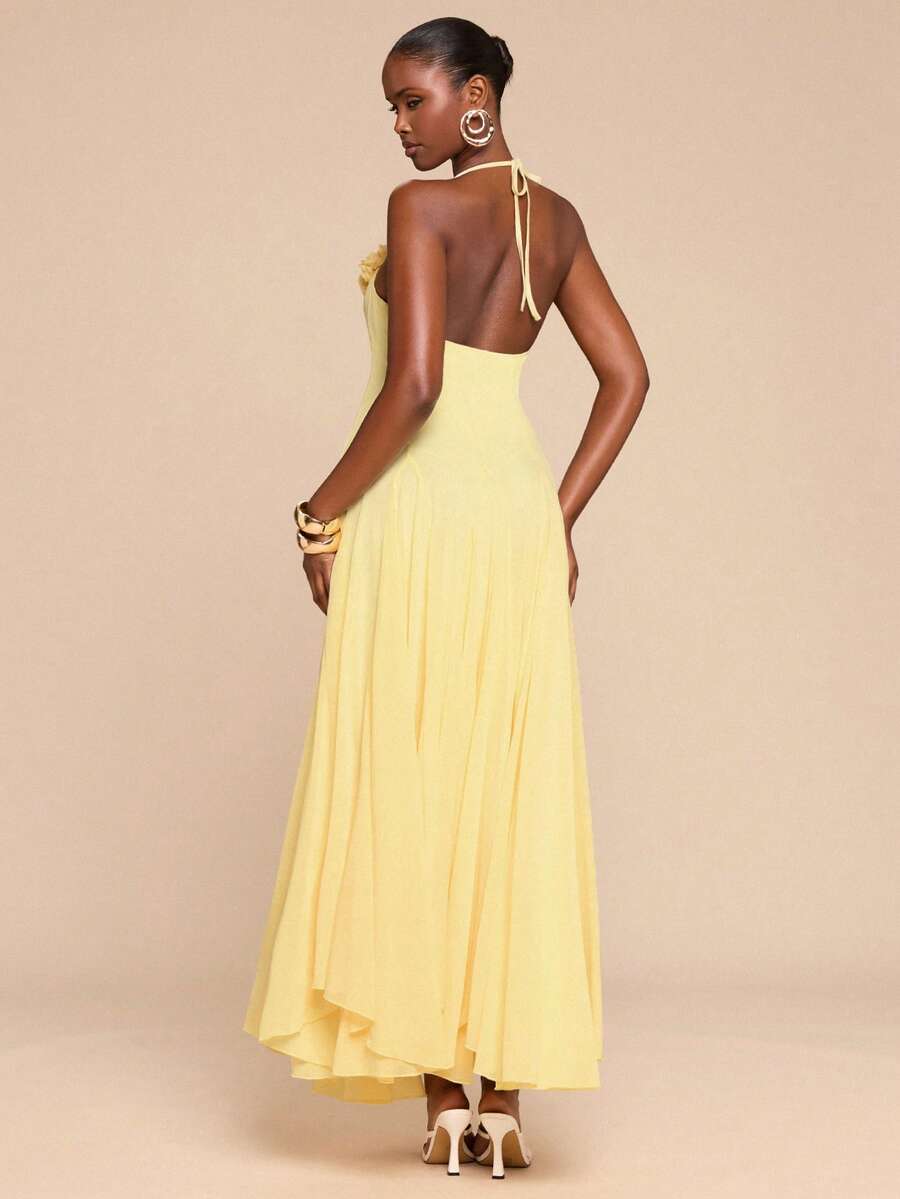 Back view pale yellow halter maxi dress with tie neck open back and flowing skirt