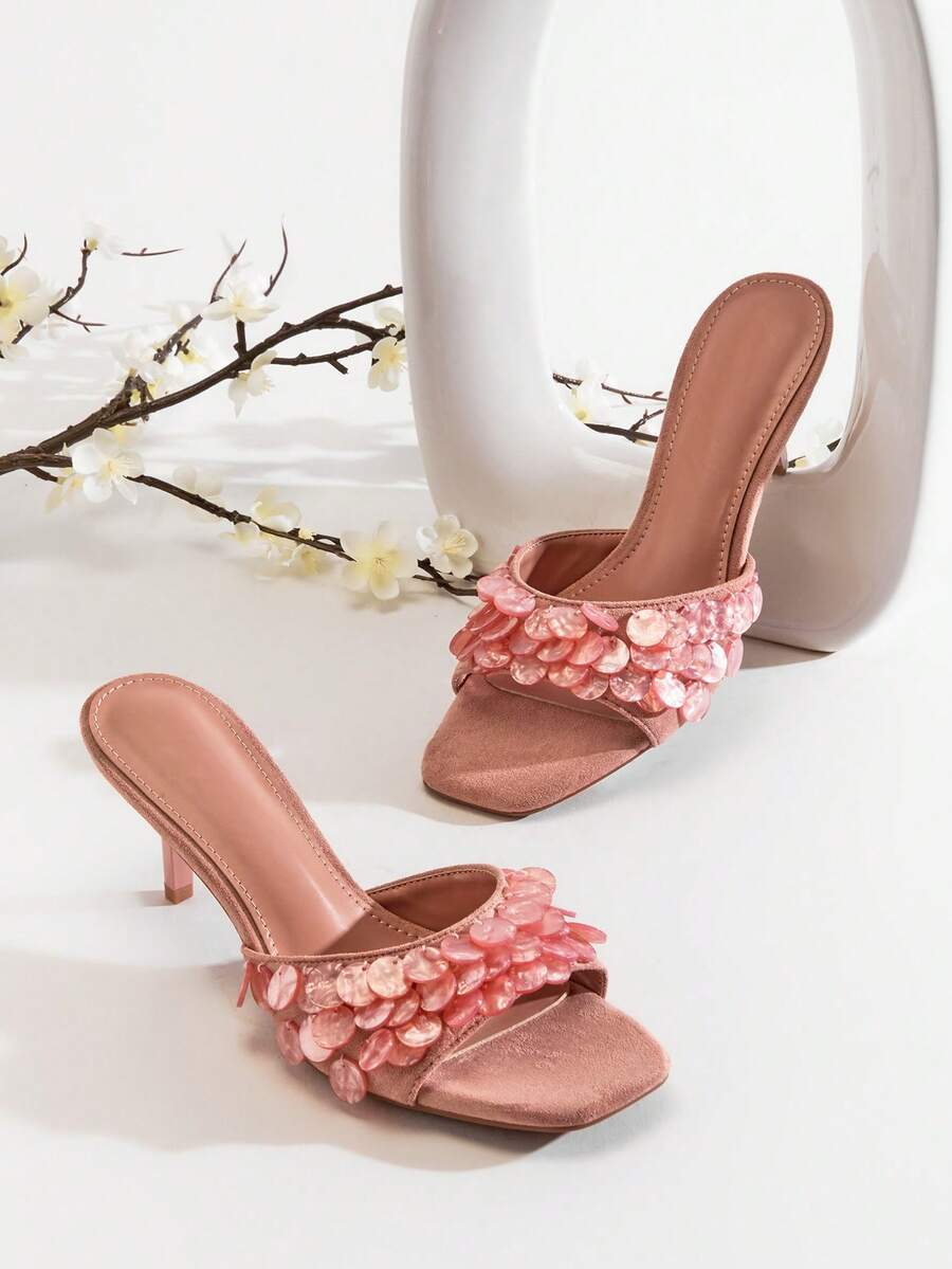 Front product view of coral pink square-toe mules with iridescent paillette strap details