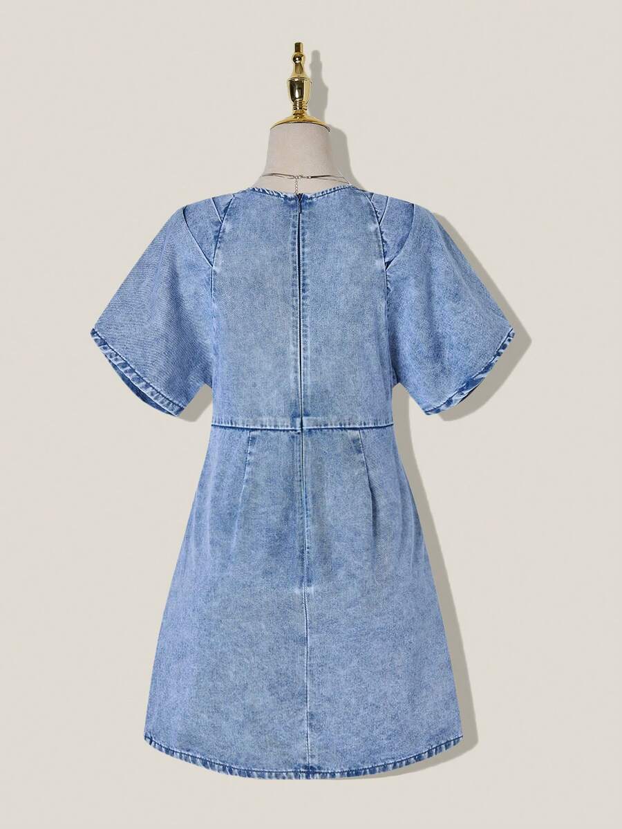 Back view of light-wash denim mini dress showing rounded neckline and center-back zipper