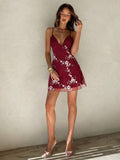 Detail view of black floral embroidered spaghetti strap mini dress with embroidered detail