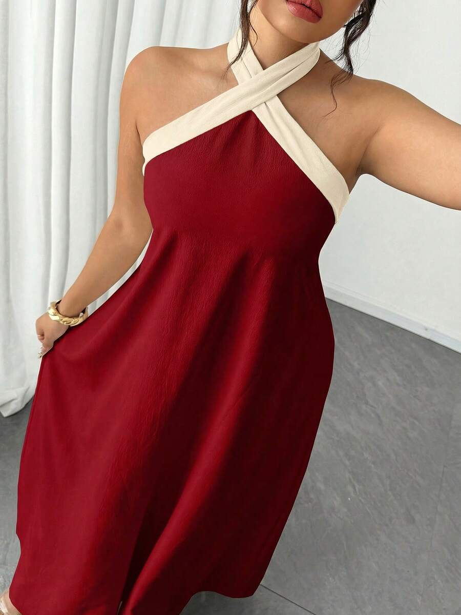 Elevate your wardrobe with this stunning plus-size halter neck maxi dress in rich burgundy. Featuring a flattering A-line silhouette with a backless design and criss-cross detailing, this versatile piece transitions seamlessly from casual outings to formal events. The split sleeves and contrast binding add contemporary flair, while the natural waistline creates a refined, elongated look. Crafted from a woven polyester-elastane blend, this dress offers comfortable everyday wear with sophisticated style. Perf