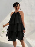 Front view of black tiered halter dress with layered skirt