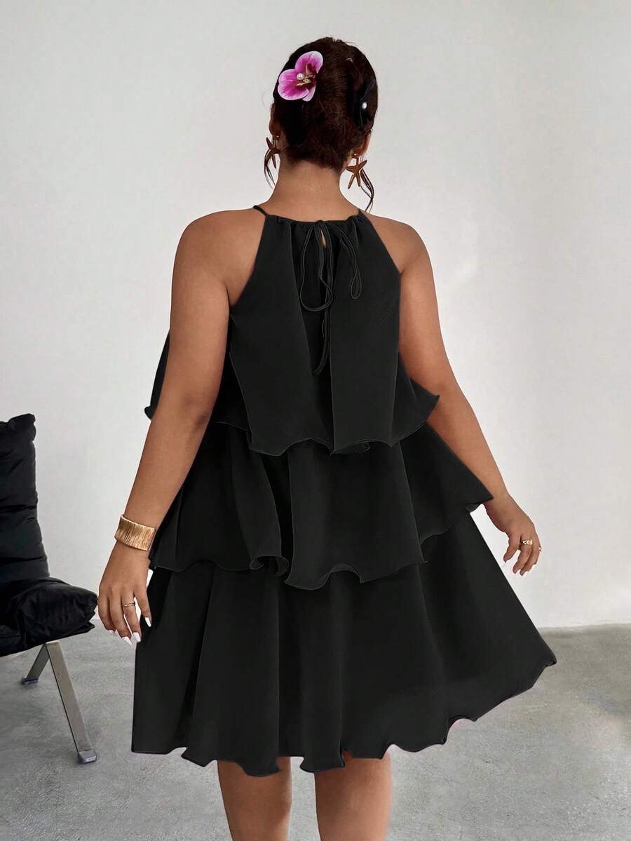 Back view of black tiered halter dress with tie detail