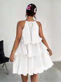 Back view of white tiered halter dress with tie detail