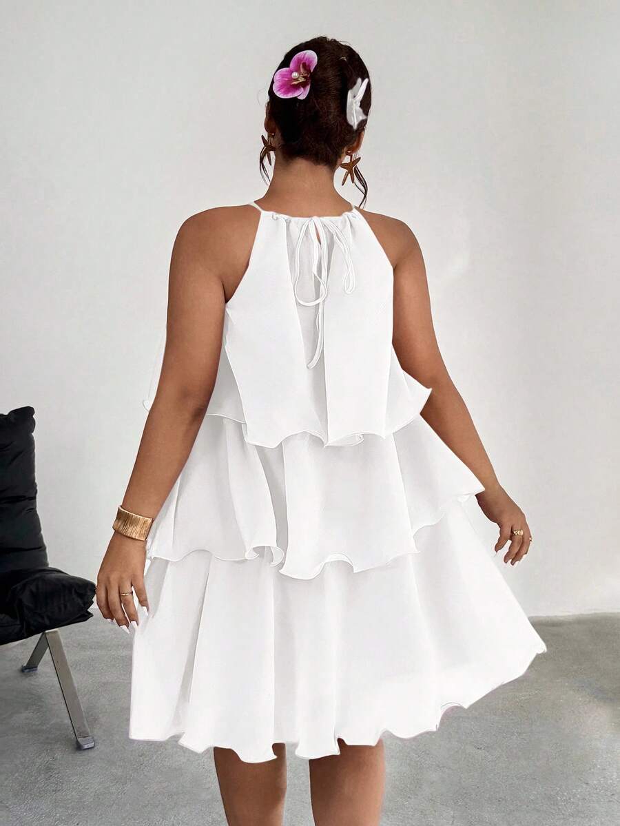 Back view of white tiered halter dress with tie detail