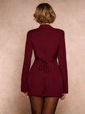 tailored blazer mini dress in burgundy, black and cream with deep V notched lapels, long sleeves, structured shoulders, three gold buttons, cinched waist, back tie, front draped mini skirt and side ruching slit image 2