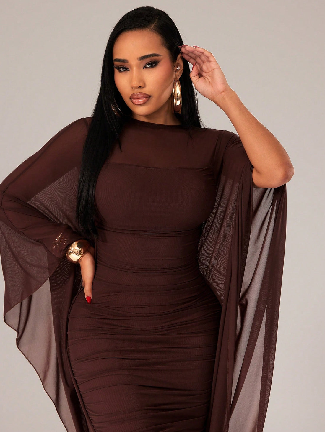Make a sophisticated statement at your next formal event in this coffee brown mesh ruffle dress. The dramatic cape sleeves add an air of elegance and movement, while delicate mesh ruffles create textured dimension throughout. Designed for special occasions, this piece combines refined details with flattering silhouette. Perfect for galas, weddings, and upscale celebrations where you want to stand out with understated luxury and timeless style.