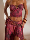 Front studio view of burgundy abstract print mesh bandeau crop top and flowing high-slit maxi skirt two-piece set for beach vacation styling