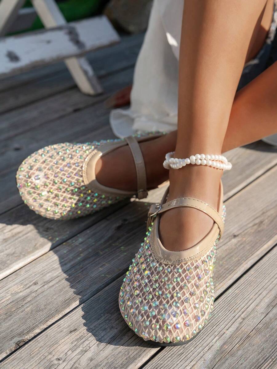 Beige rhinestone mesh Mary Jane flats on model with rounded square toe and buckle strap on wooden deck