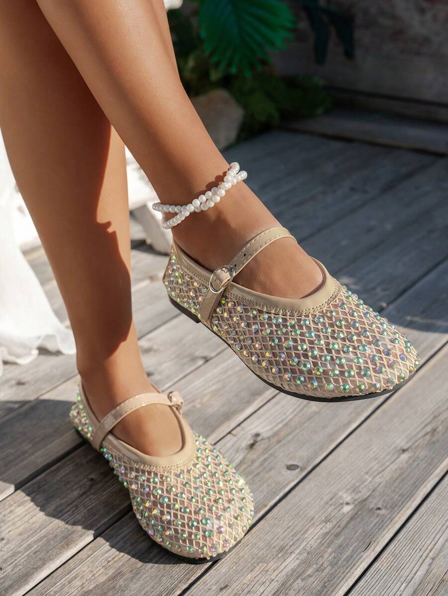 Beige rhinestone mesh Mary Jane flats on model with rounded square toe and buckle strap on wooden deck
