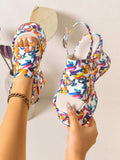 Hand-held and worn view of multicolor open toe wedge sandal with buckle strap