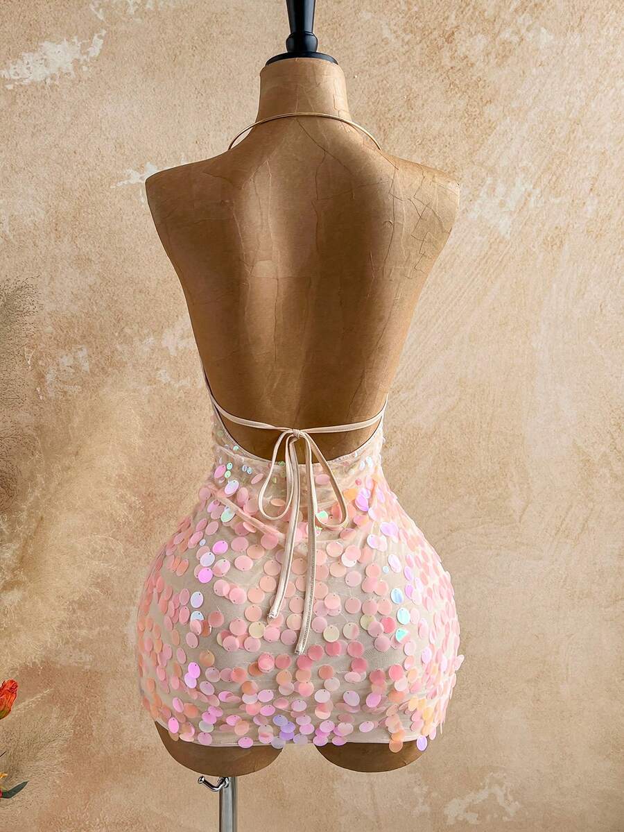 Turn heads in this stunning sequin mini dress designed for unforgettable nights out. Featuring a bold metal draped halter neckline and daring backless design, this bodycon silhouette hugs your curves perfectly while the tie-back detail adds an elegant touch. The shimmering sequin fabric catches the light beautifully, making it ideal for parties and summer getaways. Lined for comfort and crafted from a stretchy polyester-elastane blend, this pink beauty offers both style and wearability. Hand wash to maintai