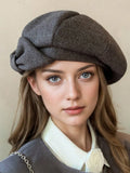 Front view of gray and dark brown beret panels with folded bow accent