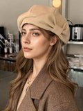 Model in beige bow beret and brown coat for cool-weather street style