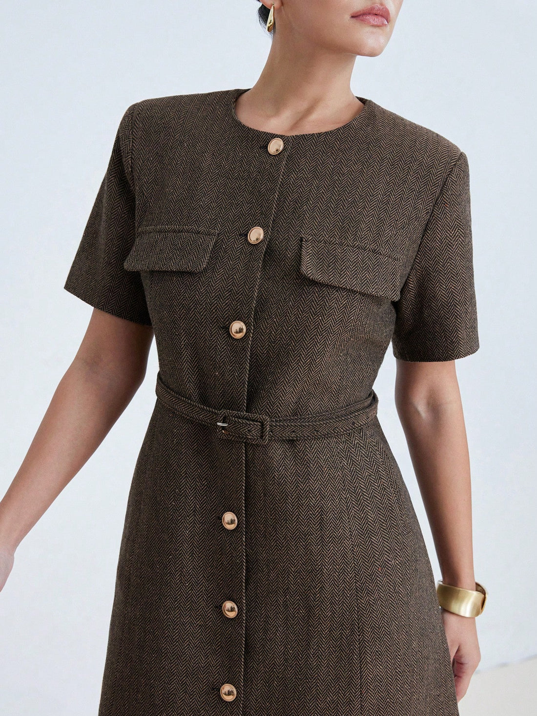 Elevate your everyday wardrobe with this sophisticated herringbone textured dress, designed for modern elegance. The structured short sleeves provide a polished silhouette, while the integrated belt cinches at the waist to define your figure and create flattering proportions. Crafted with attention to detail, the subtle herringbone weave adds visual interest and dimension without overwhelming the clean lines of the design. Perfect for transitioning from office to evening occasions, this versatile piece pair