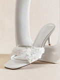 Front product view of white square-toe mule sandals with translucent disc embellishments