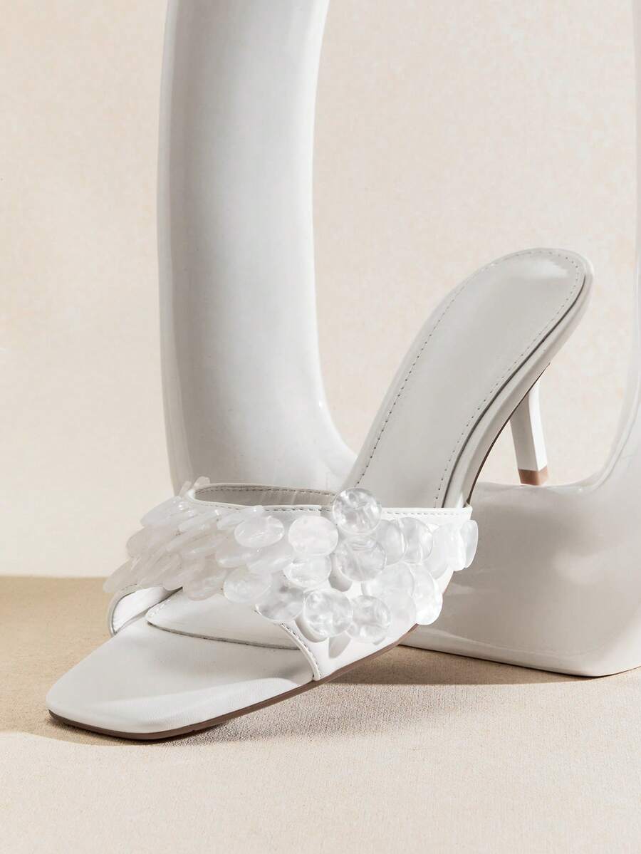 Front product view of white square-toe mule sandals with translucent disc embellishments