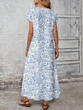Back view of blue and white botanical maxi dress with center seam and short sleeves