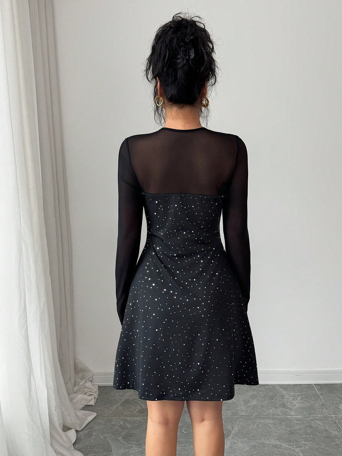 This sophisticated black mesh sequin dress combines timeless elegance with contemporary flair. The fitted silhouette flatters your frame while the delicate sequin detailing catches light beautifully, making it perfect for evening events and special occasions. The signature bow tie front adds a refined focal point, and long sleeves provide versatile coverage. The slim cut creates a polished, streamlined look that transitions seamlessly from cocktail parties to upscale dinners. Crafted for those who appreciat