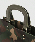 Close-up of olive green stitched handbag handles, gold-tone rings and camouflage fabric with rivets