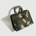 Angled view of army green camouflage square handbag showing gusseted side and twin rounded handles