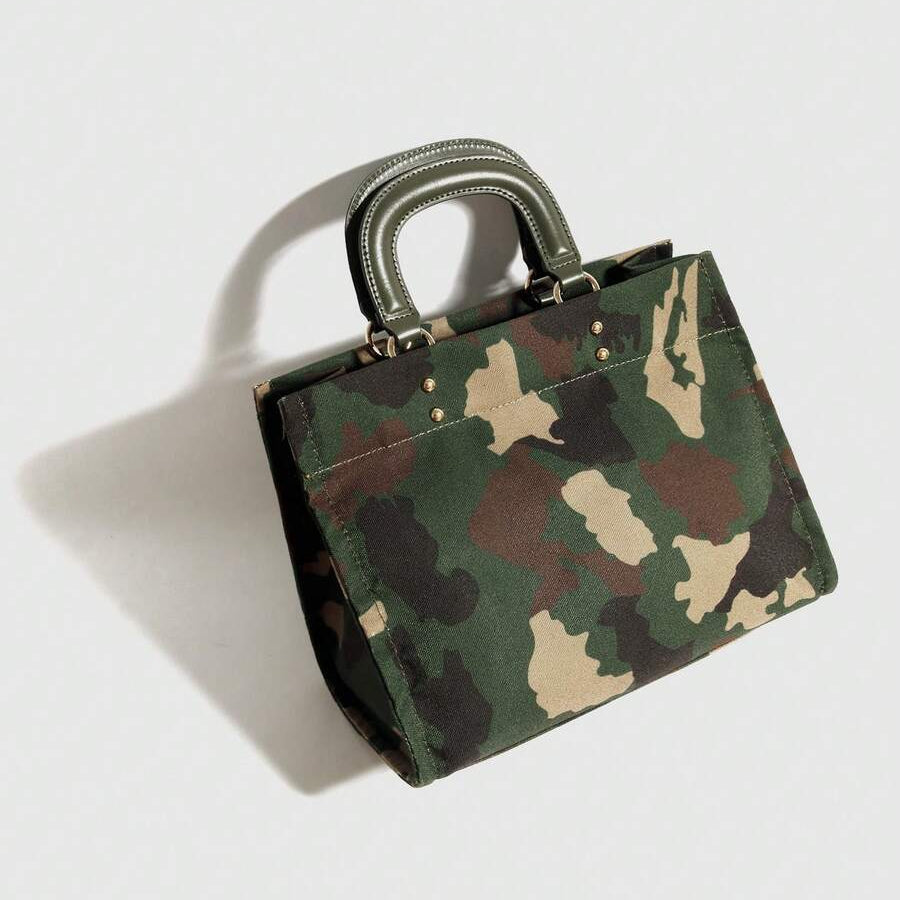 Angled view of army green camouflage square handbag showing gusseted side and twin rounded handles