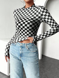 Close front view of black and white checkerboard knit shirt with lettuce-trim collar and hem
