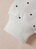 Close-up of white polka dot hoodie sleeve and ribbed cuff construction