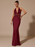 Woman wearing a burgundy evening gown with lace detailing on a beige background
