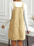 Back view of sand khaki denim pinafore dress showing low square back and faded wash