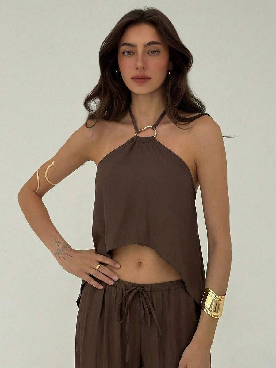 Effortless style meets everyday comfort with this khaki minimalist 2-piece set. The backless camisole features a sleek, modern silhouette perfect for layering or wearing solo, while the loose-fitting long pants provide relaxed movement and a flattering drape. 
